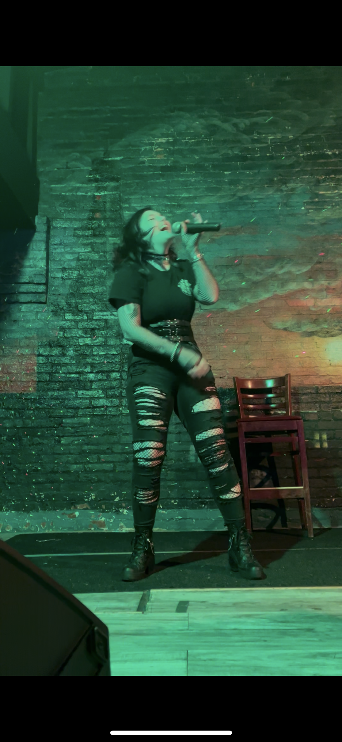 Performer singing at Queeraoke event